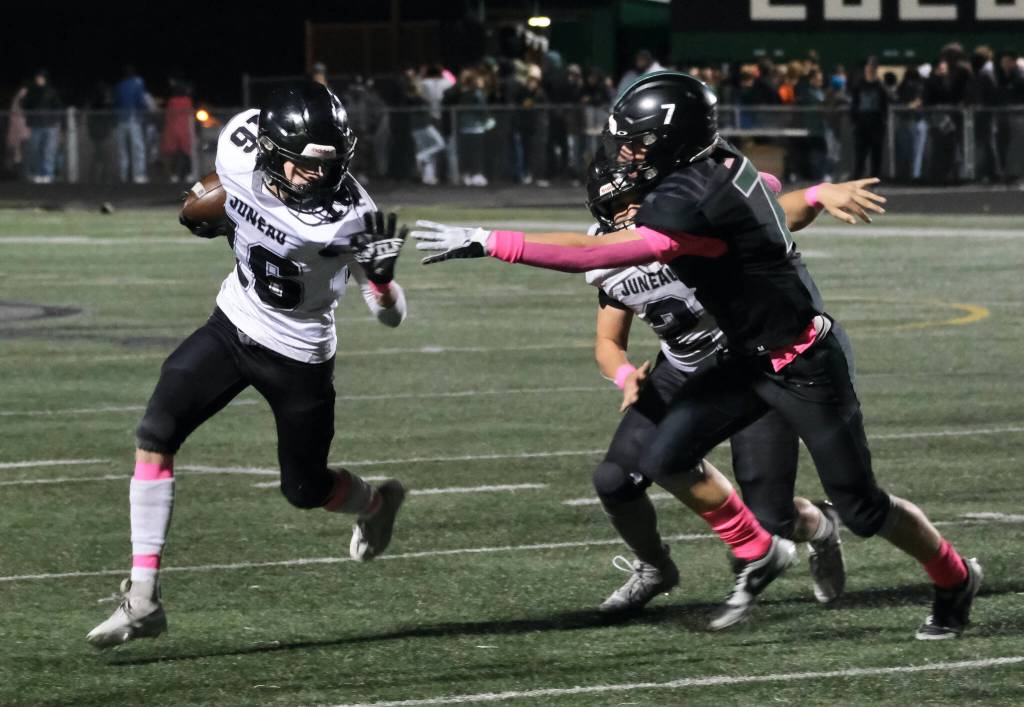 Juneau senior Caleb Ziegenfuss (16) uses a block by senior Hayden Aube (2) to run past Colony senior Tegan Olson (7) during the Huskies 42-6 win over the Knights on Friday in Palmer. (Klas Stolpe / Juneau Empire)