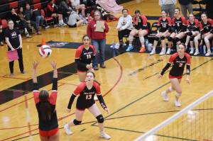 June Troxel (left), a sophomore for Juneau-Douglas High School: Yadaa.at Kalés varsity volleyball team, sets up a teammate during Saturdays game against Mountain City Christian Academy in an elimination game of the Juneau Invitational Volleyball Extravaganza at JDHS. Pictured on the court with Troxel are Amelia Elfers (13), Lavinia Maake (11) and Braith Dihle (2). Head Coach Jody Levernier is standing behind them holding a clipboard. (Mark Sabbatini / Juneau Empire)