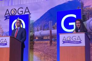 Republican challenger Nick Begich III and Democratic U.S. Rep. Mary Peltola are on the stage at the beginning of the Alaska Oil and Gas Associations candidate forum on Aug. 28, 2024. (Andrew Kitchenman/Alaska Beacon)