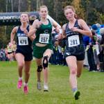 Juneau-Douglas High School: Yadaa.at Kalé Crimson Bears senior Della Mearig (281) sprints ahead of Soldotna senior Annie Burns (476) and Colony sophomore Elsie LeCount (157) at the finish of Saturdays Division 1 girls 2024 ASAA Cross-Country Running State Championship on the Bartlett High School Trails in Anchorage. (Klas Stolpe / Juneau Empire)