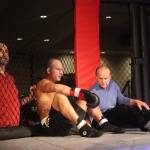 Tyson Duckworth (center) sits down in the corner of his ring, joining a call from the audience to extend his boxing match against Marco Reina to five rounds instead of three during the main event of AK Beatdown 36 on Saturday night at Elizabeth Peratrovich Hall. (Mark Sabbatini / Juneau Empire)