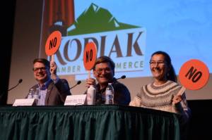 From left to right, Nick Begich, Republican candidate for U.S. House; Alaskan Independence Party candidate John Wayne Howe and Rep. Mary Peltola, D-Alaska, hold up paddles indicating their opposition to finfish farming in Alaska. Howe had jokingly looked at Begichs paddle before making a decision. (James Brooks/Alaska Beacon)