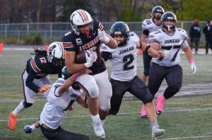 Juneau Huskies senior Jayden Johnson (4), senior Hayden Aube (2) and junior Ricky Tupou (77) try to bring down West Anchorage senior Zephaniah Sailele (6) during the Huskies 20-13 loss to the Eagles in the 2024 ASAA State Football Playoffs on Saturday at West Anchorages Nest on Hillcrest. (Klas Stolpe/Juneau Empire)
