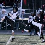 Juneau senior Sage Schultz (5) intercepts a pass to West Anchorage senior Ariel Sanchez (2) as Juneau junior Daniel Campbell (8) covers the outside during the Huskies 20-13 loss to the Eagles in the 2024 ASAA State Football Playoffs on Saturday at West Anchorages Nest on Hillcrest. (Klas Stolpe/Juneau Empire)
