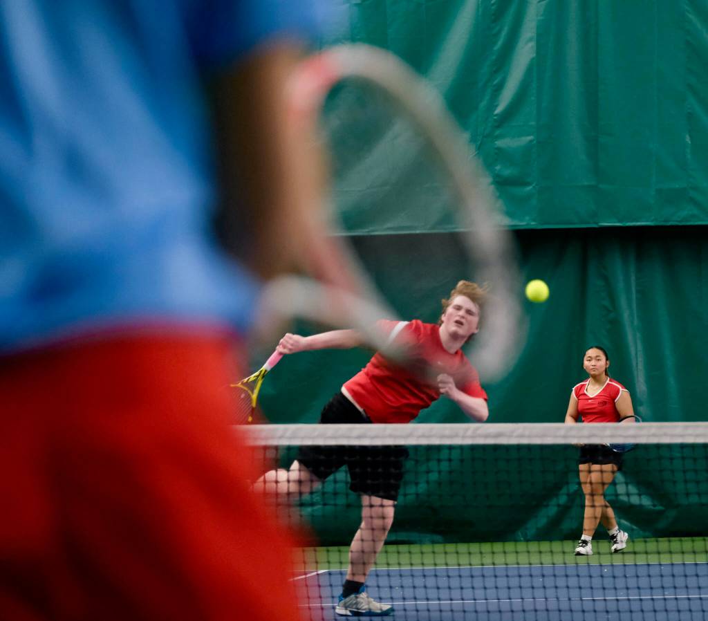 Juneau-Douglas High School: Yadaa.at Kalé senior Alex Rehfeldt hits a shot as senior partner Milina Mazon looks on during a mixed doubles match at the 2024 ASAA Tennis Championship on Saturday at Anchorages Alaska Club. (Klas Stolpe / Juneau Empire)