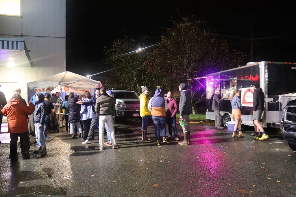 People gather around food trucks in the KTOO parking lot during the stations 50-Fest on Saturday night. (Mark Sabbatini / Juneau Empire)