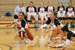 Juneau-Douglas High School: Yadaa.at Kalés Leila Cooper, June Troxel and Braith Dihle dive for the ball during their 25-19, 25-16, 25-15 victory over Ketchikan High School at the Clarke Cochrane Gymnasium on Saturday, Oct. 12, 2024. (Christopher Mullen/ Ketchikan Daily News)