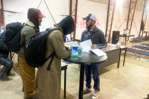 Juvencio Garcia (right) has people sign in to stay at the citys cold-weather emergency shelter in Thane on the first night of its second year of operation Tuesday. Garcia was among those who stayed at the shelter last year and said he hopes to provide the help shelter staff from the first season provided him. (Mark Sabbatini / Juneau Empire)