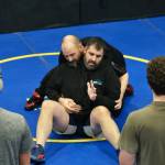 Juneau-Douglas High School: Yadaa.at Kalé Crimson Bears Wrestling coaches Adam Messmer and Dan Ondrejka demonstrate a move during practice on Wednesday. (Klas Stolpe/Juneau Empire)