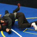 Senior Camden Messmer works a pin on freshman Nixie Schooler. during the Juneau-Douglas High School: Yadaa.at Kalé Crimson Bears wrestling team practice on Wednesday. (Klas Stolpe/Juneau Empire)