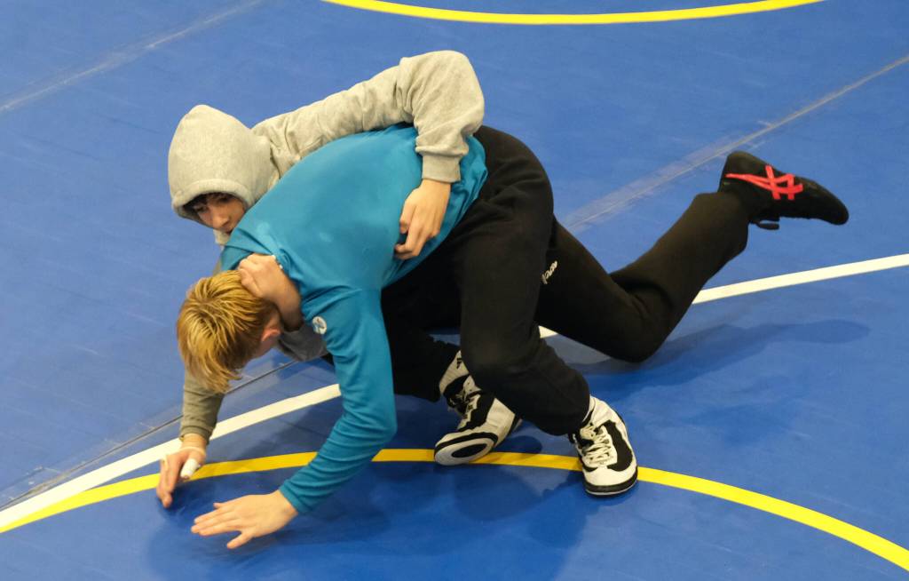 Sophomore Landon Dunn practices a takedown on senior Colton Cummins during the Juneau-Douglas High School: Yadaa.at Kalé Crimson Bears wrestling team practice on Wednesday. (Klas Stolpe/Juneau Empire)