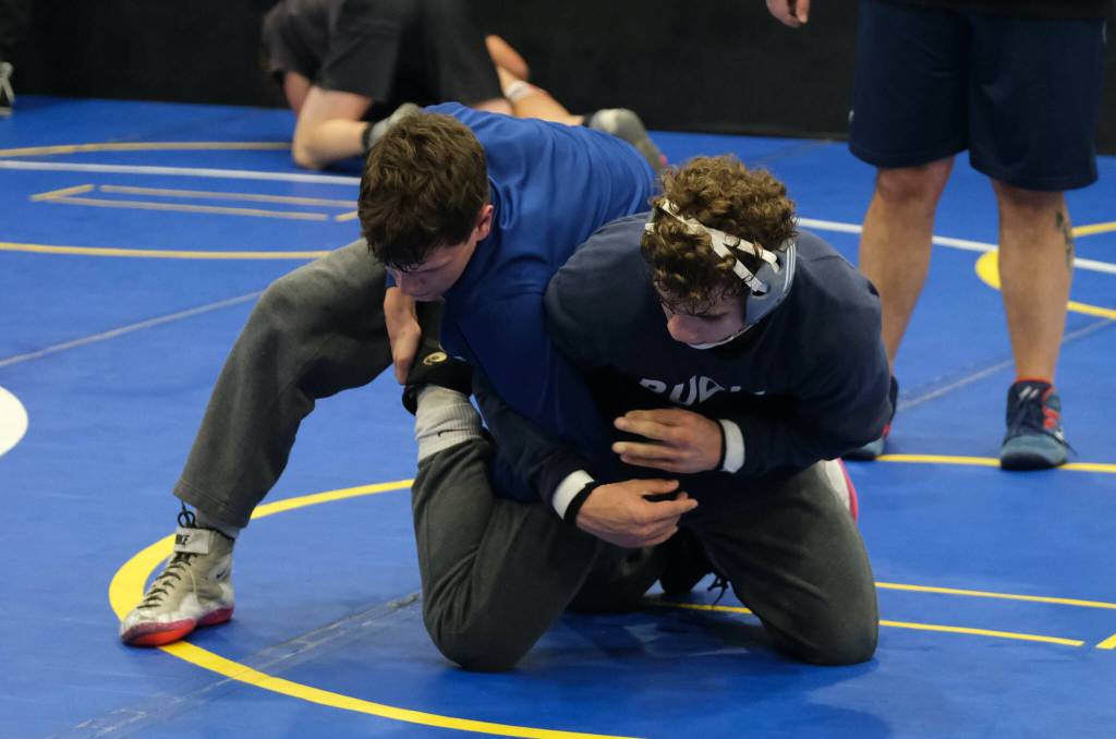 Sophomore Jed Davis wrestles with junior Oliver Able during the Juneau-Douglas High School: Yadaa.at Kalé Crimson Bears wrestling team practice on Wednesday. (Klas Stolpe/Juneau Empire)