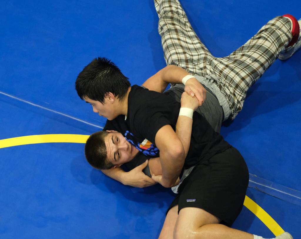 Senior Hayden Aube works a pin on junior Jaxin Jim. during the Juneau-Douglas High School: Yadaa.at Kalé Crimson Bears wrestling team practice on Wednesday. (Klas Stolpe/Juneau Empire)