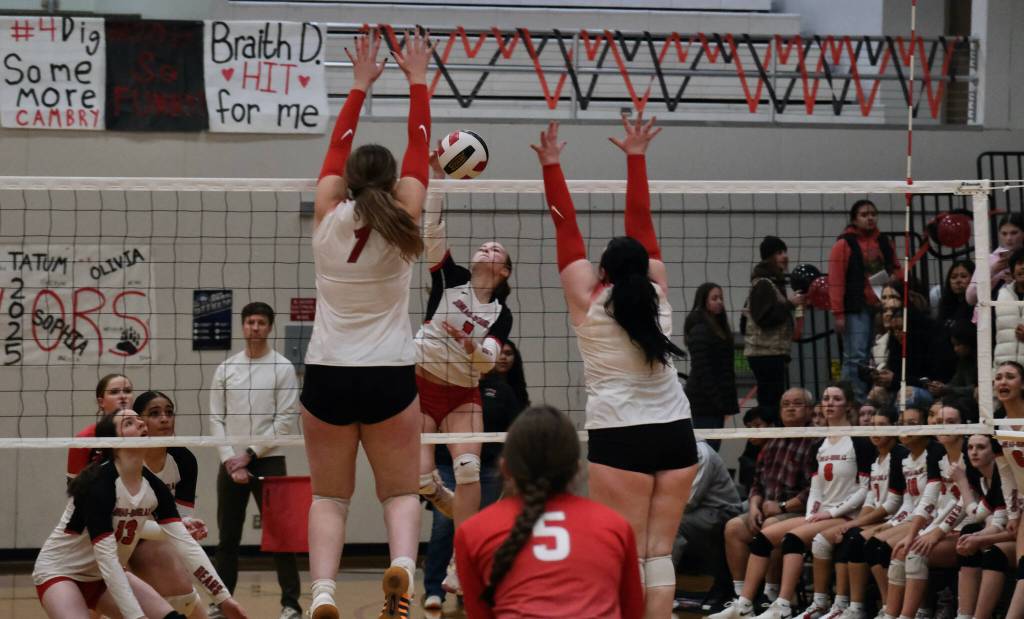 Juneau-Douglas High School: Yadaa.at Kalé sophomore June Troxel (1) kills a shot between Wasilla seniors Layla Hays and Hayden Caldera during the Crimson Bears loss to the Warriors on Friday night at the George Houston Gymnasium. (Klas Stolpe/Juneau Empire)