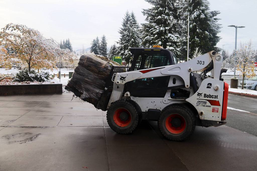 A loader carries a pallet of sandbags to the entrance of the Mendenhall Valley Public Library on Saturday morning. The City and Borough of Juneau received 75,000 sandbags from the U.S. Army Corps of Engineers that are being distributed free to residents. (Mark Sabbatini / Juneau Empire)