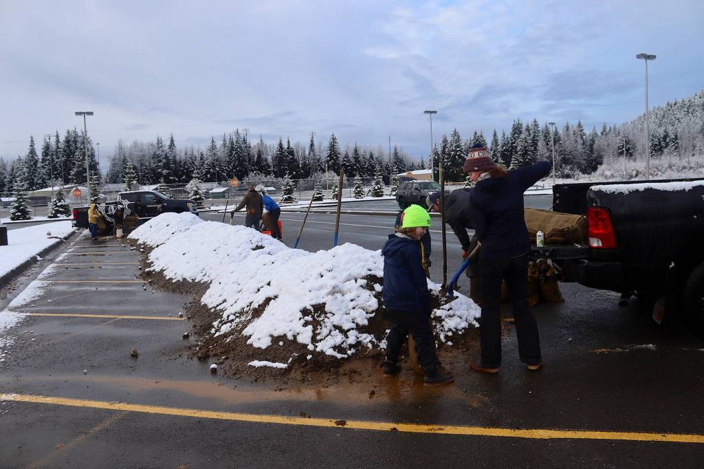 Molly Zaleski and her son, Aedan, 8, load sandbags from a sandpile in the parking lot of Thunder Mountain Middle School on Saturday morning. (Mark Sabbatini / Juneau Empire)