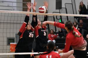 Juneau-Douglas High School: Yadaa.at Kalé junior Natalia Harris (20) and senior Evelyn Richards (8) block a kill by Wasilla senior Layla Hays during the Crimson Bears three-set loss to the visiting Warriors on Saturday at the George Houston Gymnasium. (Klas Stolpe/Juneau Empire)
