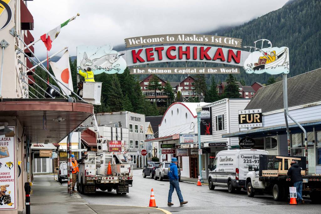 Electricians replace sections of neon tubing on a sign that greets visitors to Ketchikan, a fishing community turned cruise ship stop with a population of 8,000, Oct. 9, 2024. Deadly landslides are increasing around the world, but in parts of Alaska, maps of the hazards remain controversial. (Christopher Miller/The New York Times)