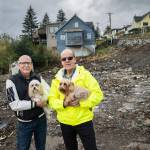 James Montiver, right, and his husband, Bill, with their dogs, Alani and Cassie, on the site of their home, which was destroyed by an August landslide, in Ketchikan on Oct. 9, 2024. Deadly landslides are increasing around the world, but in parts of Alaska, maps of the hazards remain controversial. (Christopher Miller/The New York Times)