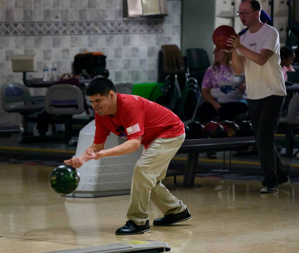 Andres Jones delivers a ball and Ryan Story waits a turn during the Juneau Special Olympics bowling games Sunday at Pinz Bowling Alley. (Klas Stolpe/Juneau Empire)