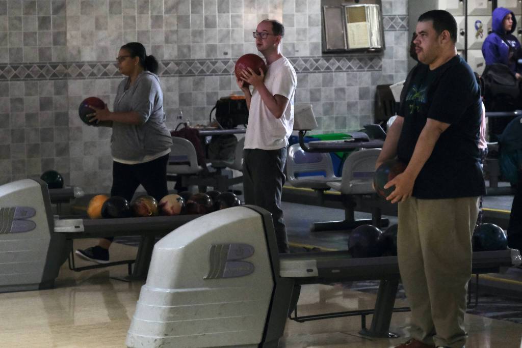 Tanya Lewis, Ryan Story and Niall Johnson wait their turn during the Juneau Special Olympics bowling games Sunday at Pinz Bowling Alley. (Klas Stolpe/Juneau Empire)