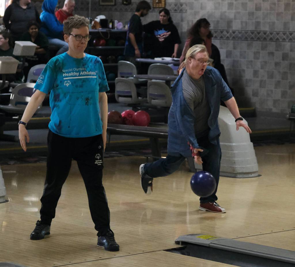Tammi Birch watches her ball while Jake Mallinger delivers a ball during the Juneau Special Olympics bowling games Sunday at Pinz Bowling Alley. (Klas Stolpe/Juneau Empire)