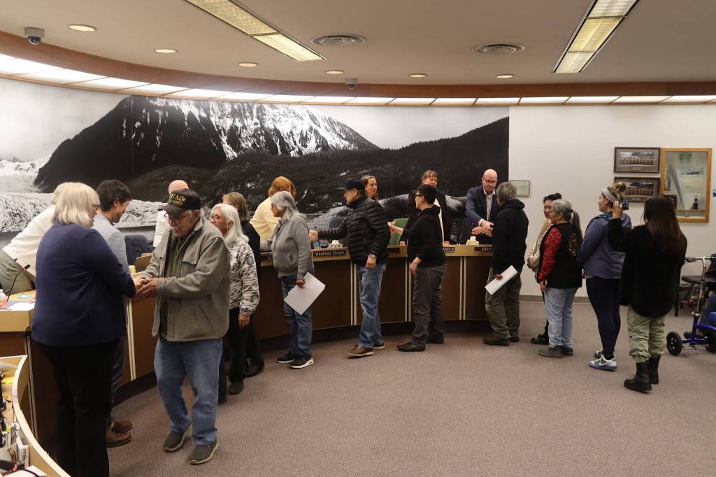 Douglas Indian Association members greet city leaders after receiving an apology from the City and Borough of Juneau during an Assembly meeting Monday night for the citys role in the burning of the Douglas Indian Village in 1962. (Mark Sabbatini / Juneau Empire)
