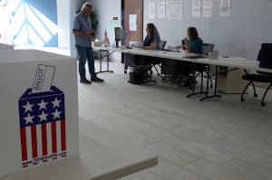 A voter receives his ballot for Alaskas primary election at the Mendenhall Mall Annex on Aug. 17. (Laurie Craig / Juneau Empire file photo)