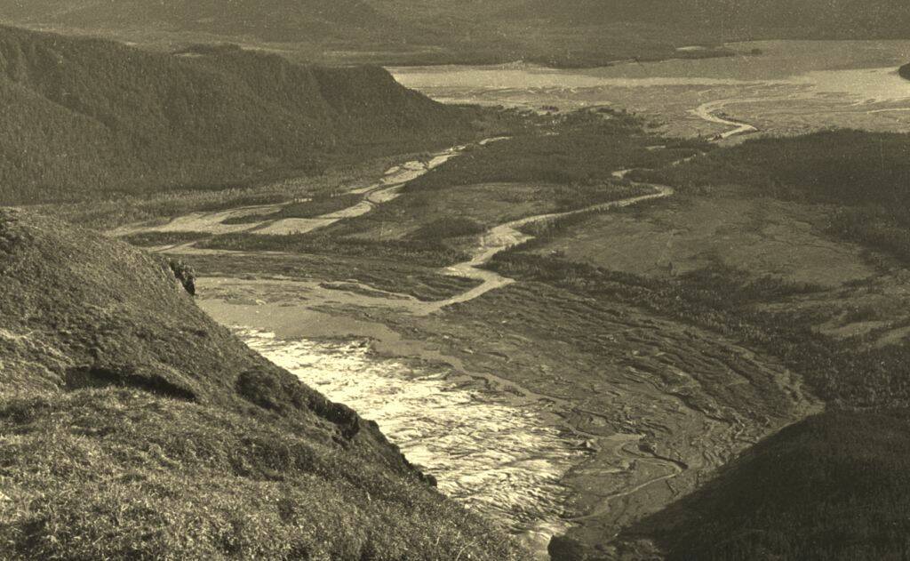 This photo was taken from the top of Mount McGinnis in 1894 as part of a series of photos used to triangulate summit peaks for establishing the border between Alaska and Canada. Canadian surveyor William Ogilvie turned his glass plate negative camera toward the ocean and toward Mendenhall Valley to give a view of the large fan-shape of glacier, rows of moraines and no lake. (Courtesy Jim Geraghty and National Snow and Ice Data Center)