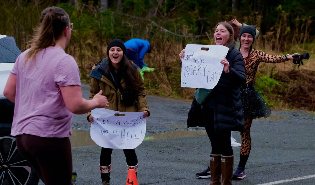 Friends and race fans cheer on runners during the Halloween Half Marathon and 5K on Saturday along North Douglas Highway. (Klas Stolpe / Juneau Empire)
