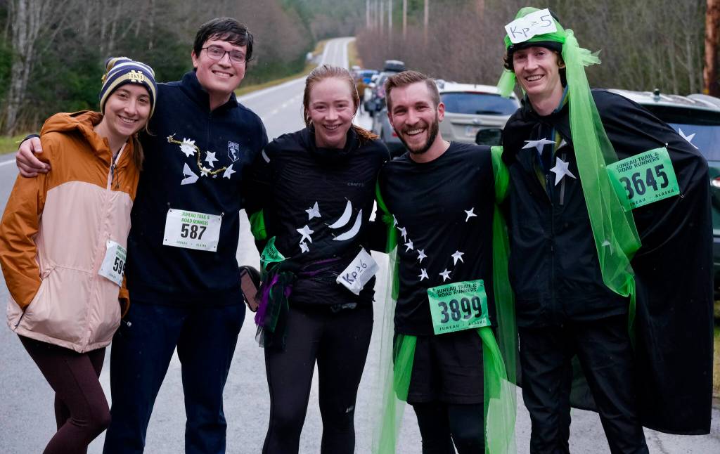 Members of the costume winning Northern Lights, from left, Mary Scartz, Juan Llovet, Maggie Lenhart, John Moreland and Ian Novak pose at the finish of the Halloween Half Marathon and 5K on Saturday along North Douglas Highway. (Klas Stolpe / Juneau Empire)