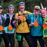 Brooke Field, Ashleigh McAndrew, Jenna Wiersma, Megan Hendrickson and Stephanie Sauve display their gifted pumpkin medals, made by Megans husband Adam, after the Halloween Half Marathon and 5K on Saturday along North Douglas Highway. (Klas Stolpe / Juneau Empire)