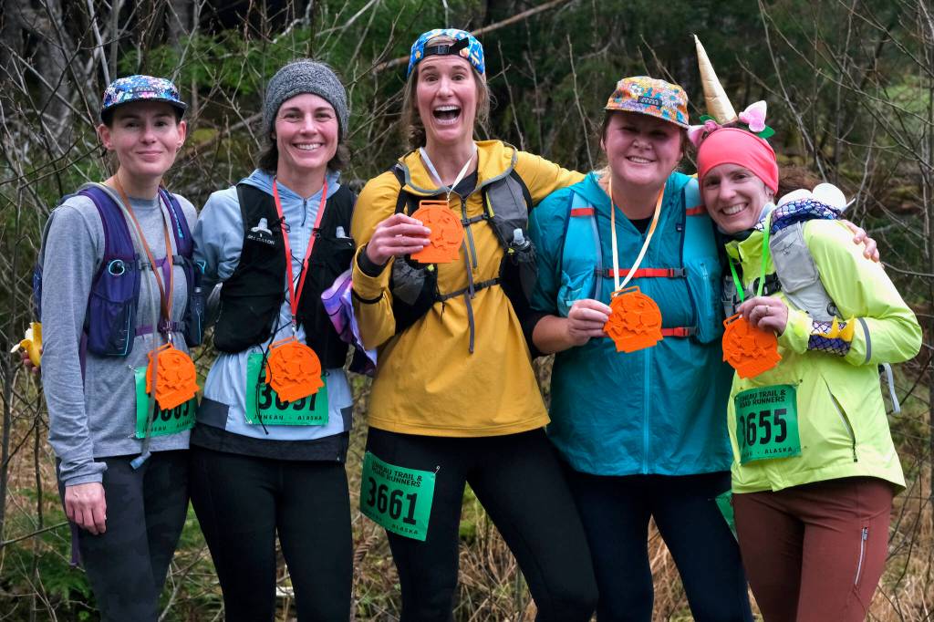 Brooke Field, Ashleigh McAndrew, Jenna Wiersma, Megan Hendrickson and Stephanie Sauve display their gifted pumpkin medals, made by Megans husband Adam, after the Halloween Half Marathon and 5K on Saturday along North Douglas Highway. (Klas Stolpe / Juneau Empire)