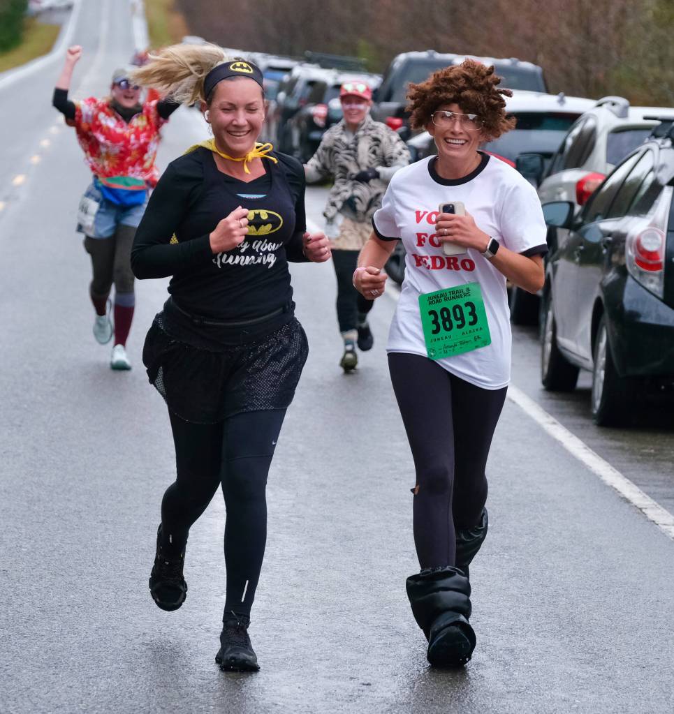 Jessica Geary and Amanda Kohan finish the Halloween Half Marathon and 5K on Saturday along North Douglas Highway. (Klas Stolpe / Juneau Empire)