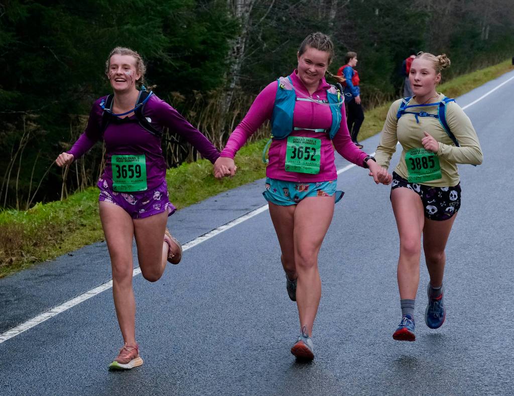 Acey Wall, Bailey Roguska and Grace Gadzig finish the Halloween Half Marathon and 5K on Saturday along North Douglas Highway. (Klas Stolpe / Juneau Empire)