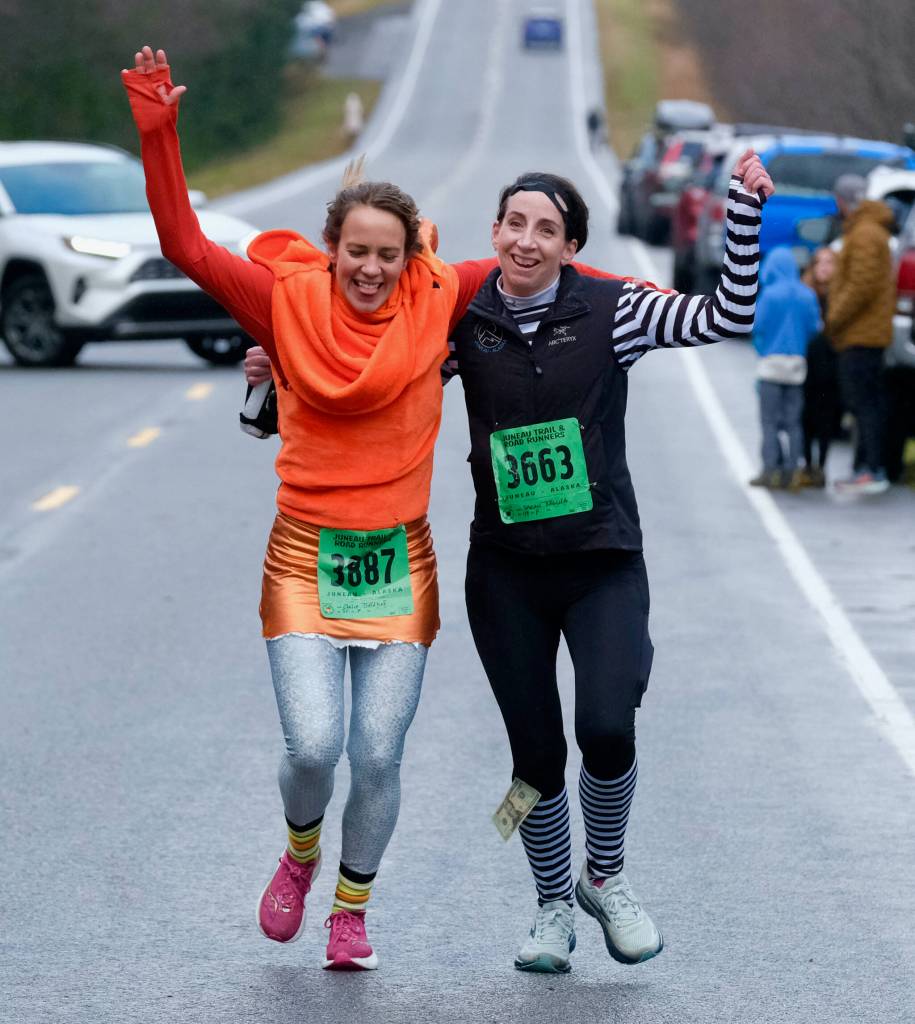 Claire Geldhof and Sarah Zaglifa finish the Halloween Half Marathon and 5K on Saturday along North Douglas Highway. (Klas Stolpe / Juneau Empire)