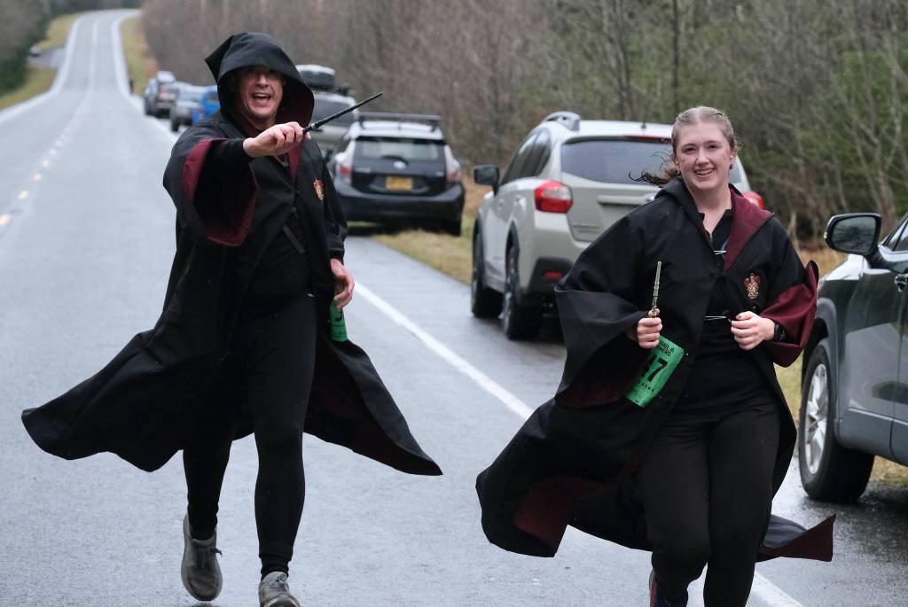 Hogwarts wizards Richard Olson and Aspen Olson finish the Halloween Half Marathon and 5K on Saturday along North Douglas Highway. (Klas Stolpe / Juneau Empire)