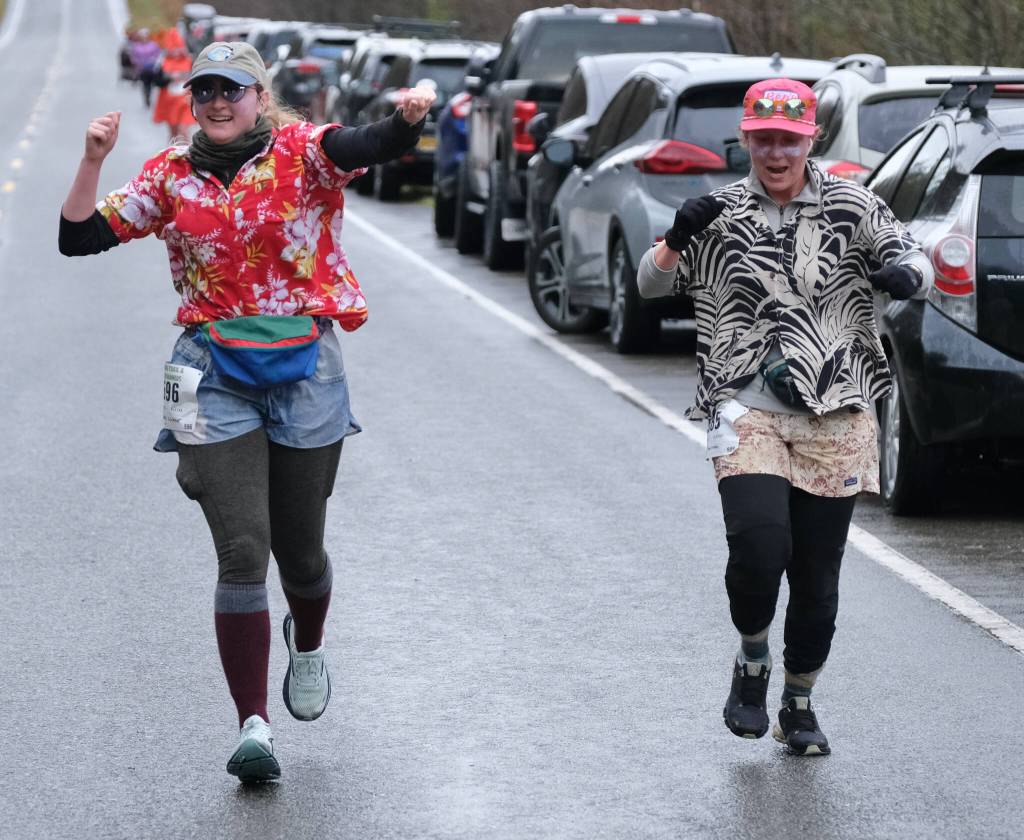 Jenna Schlener and Carly Harmon celebrate their finish in the Halloween Half Marathon and 5K on Saturday along North Douglas Highway. (Klas Stolpe / Juneau Empire)