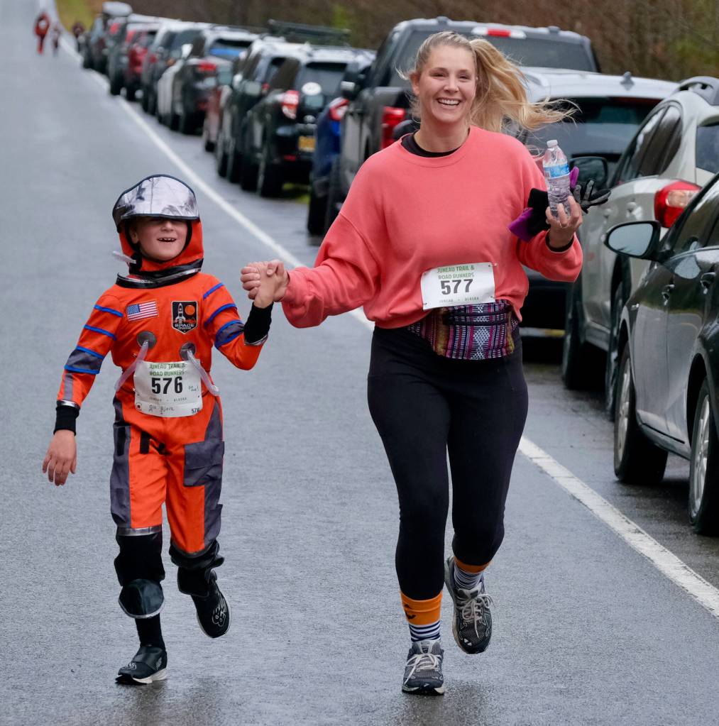Ole Bjork and Joy Bjork finish the Halloween Half Marathon and 5K on Saturday along North Douglas Highway. (Klas Stolpe / Juneau Empire)