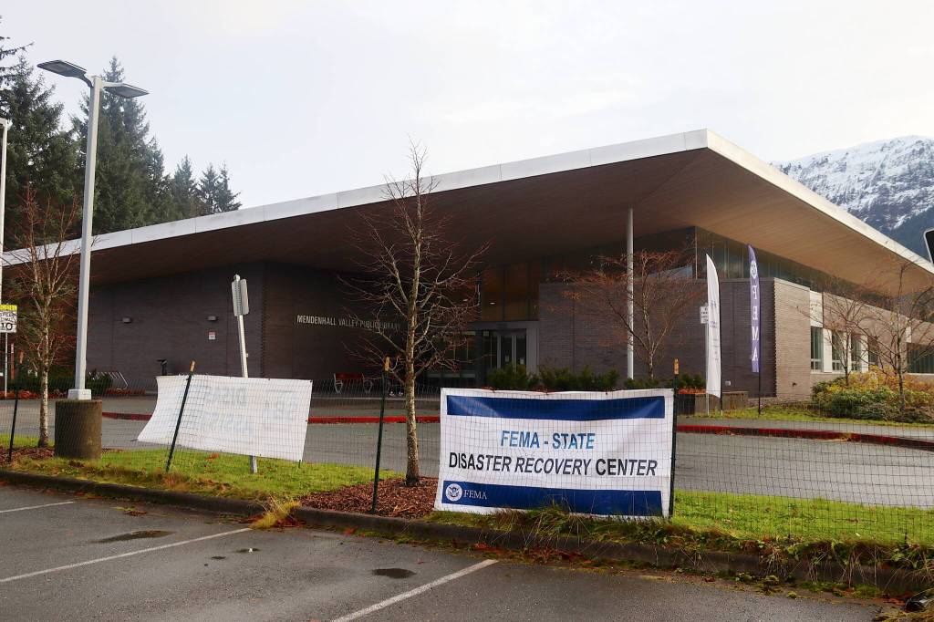 Signs outside the Mendenhall Valley Library notify people about the Federal Emergency Management Agency disaster recovery center set up inside Wednesday for residents affected by Augusts record flooding from Suicide Basin. (Mark Sabbatini / Juneau Empire)