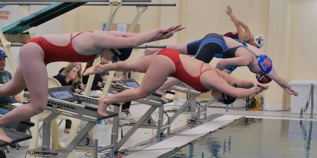 Juneau-Douglas High School: Yadaa.at Kalé sophomores Maddox Rasmussen and Amy Liddle, Sitkas Mia Turner, JDHS senior Brooklyn Kanouse and Ketchikans Macie Bullock start the girls 200 yard freestyle Friday during the 2024 Region V Swim & Dive Championships at the Petersburg Aquatic Center pool. (Klas Stolpe / Juneau Empire)
