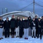 The Juneau-Douglas High School: Yadaa.at Kalé Crimson Bears volleyball team pose for a photo in Utqiagvik, formerly known as Barrow. From left are senior Evelyn Richards, junior Lavinia Maake, senior Nina Jeter, assistant coach Abby Dean, sophomore Amelia Elfers, juniors Cambry Lockhart, Braith Dihle, Neela Thomas, sophomore June Troxel, junior Natalia Harris, sophomore Leila Cooper, assistant coach Mark Ibias and sophomore Braith Dihle. (Courtesy photo)