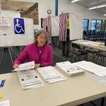 Gail Fenumiai, former director of the Alaska Division of Elections, continues to help voters in a new role as the chair of the Lynn Canal precinct in the Auke Bay ferry terminal where voters were queued at the door for the 7 a.m. Tuesday poll opening. (Laurie Craig / Juneau Empire)