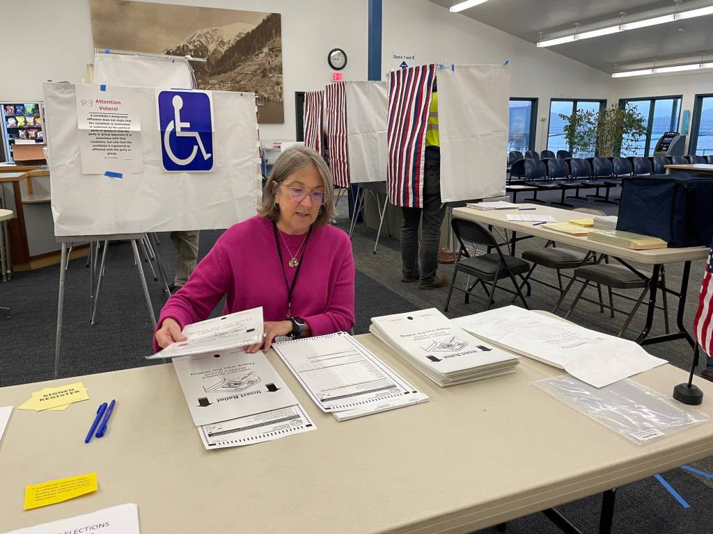 Gail Fenumiai, former director of the Alaska Division of Elections, continues to help voters in a new role as the chair of the Lynn Canal precinct in the Auke Bay ferry terminal where voters were queued at the door for the 7 a.m. Tuesday poll opening. (Laurie Craig / Juneau Empire)