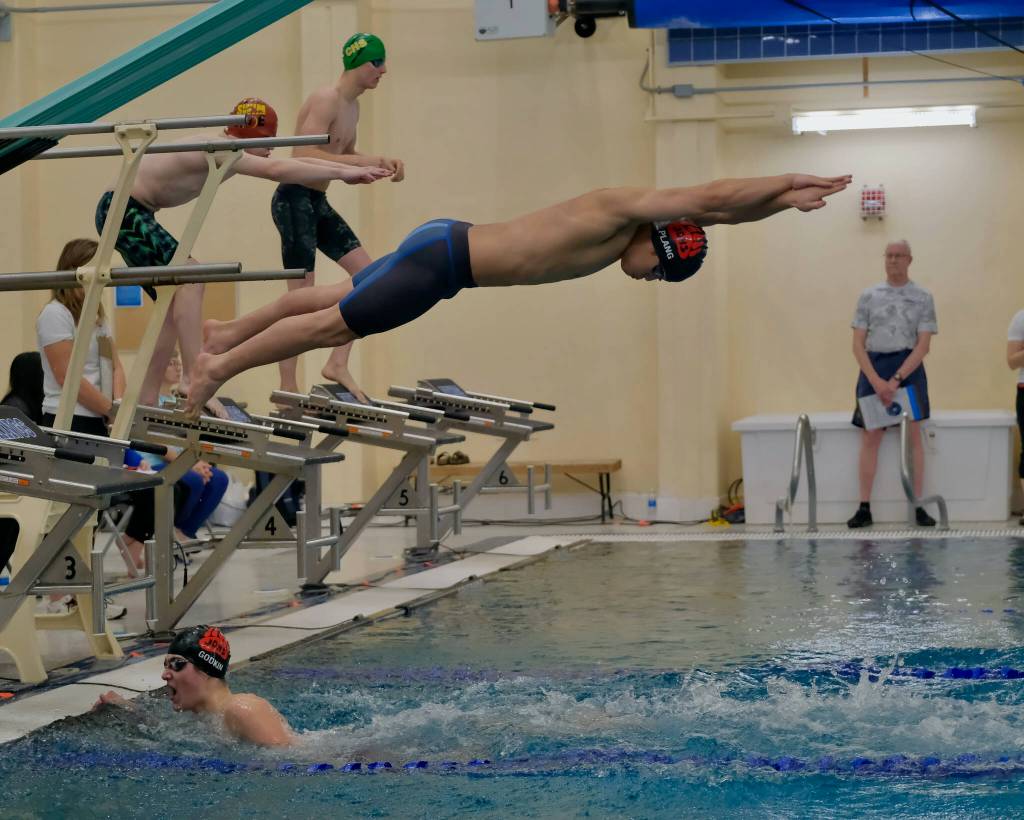 Juneau-Douglas High School: Yadaa.at Kalé senior Matthew Godkin touches the wall as senior Matthew Plang leaves the block in the boys 200 yard freestyle relay final at the Region V Championships last weekend in the Petersburg Aquatic Center. (Klas Stolpe / Juneau Empire)