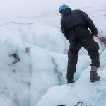 Þorsteinn Þorsteinsson looks at a moulin on the Sólheimajökull glacier on Oct. 20. A moulin, or glacier mill, is a crevasse through which water enters a glacier from the surface. (Jasz Garrett / For the Juneau Empire)