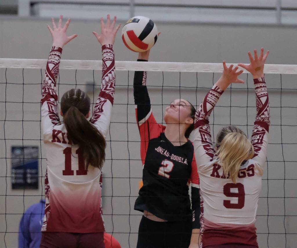 Juneau-Douglas High School: Yadaa.at Kalé junior Braith Dihle kills a shot against Ketchikan sophomore Avah Bittle (11) and junior Payton Hagan (9) during the Crimson Bears 20-25, 25-9, 25-11, 25-18 match win Friday during the Region V Volleyball Championships at Juneaus George Houston Gymnasium. (Klas Stolpe / Juneau Empire)