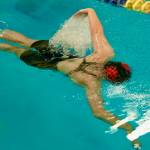 Juneau-Douglas High School: Yadaa.at Kalé sophomore Bailey Fisher breaks the surface at the start of the girls 50 freestyle final during the ASAA Swim & Dive State Championships on Saturday at Anchorages Bartlett High School pool. (Klas Stolpe / Juneau Empire)