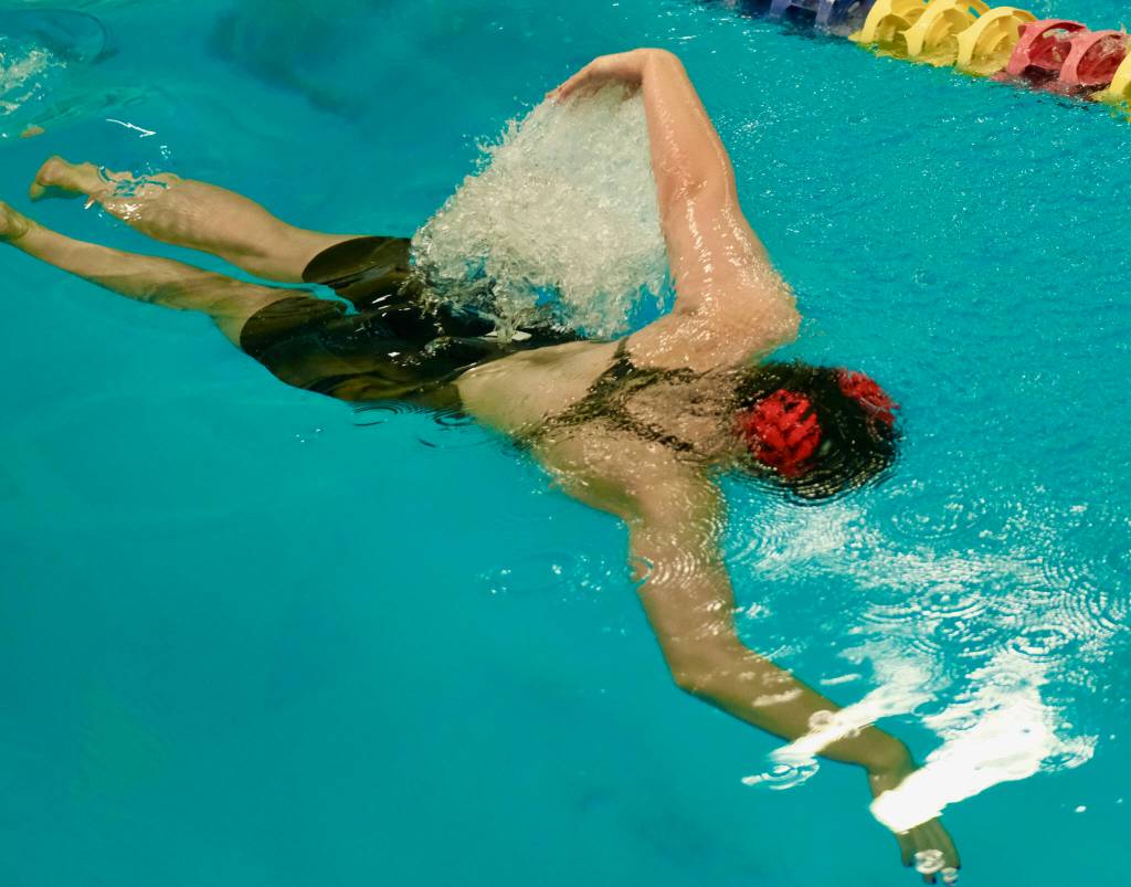 Juneau-Douglas High School: Yadaa.at Kalé sophomore Bailey Fisher breaks the surface at the start of the girls 50 freestyle final during the ASAA Swim & Dive State Championships on Saturday at Anchorages Bartlett High School pool. (Klas Stolpe / Juneau Empire)