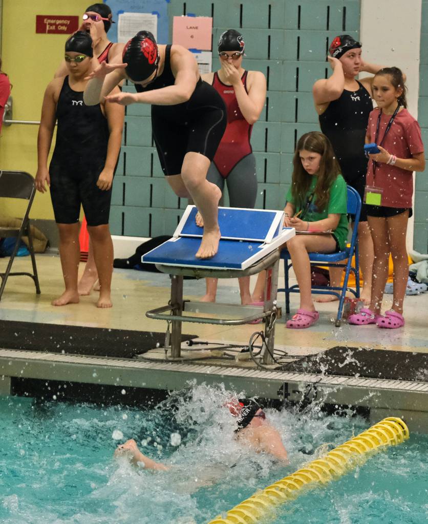 Juneau-Douglas High School: Yadaa.at Kalé senior Pacific Ricke leaves the starting block as sophomore Bailey Fisher touches in the girls 200 freestyle relay final during the ASAA Swim & Dive State Championships on Saturday at Anchorages Bartlett High School pool. (Klas Stolpe / Juneau Empire)